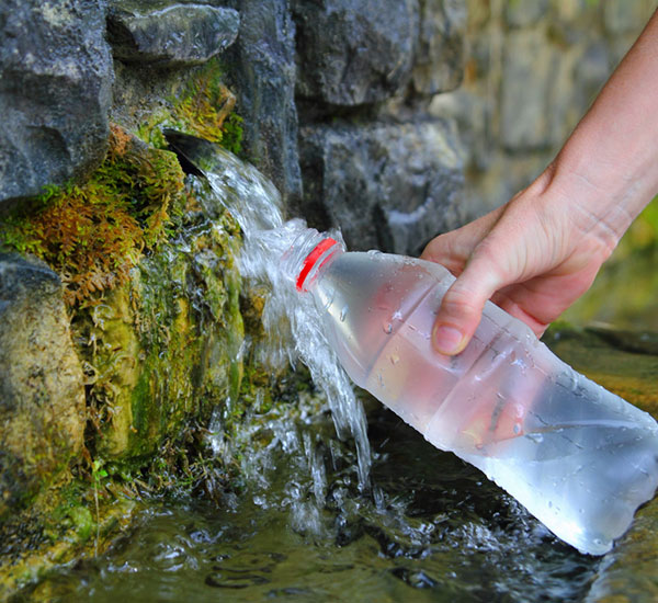 filling water bottle from spring